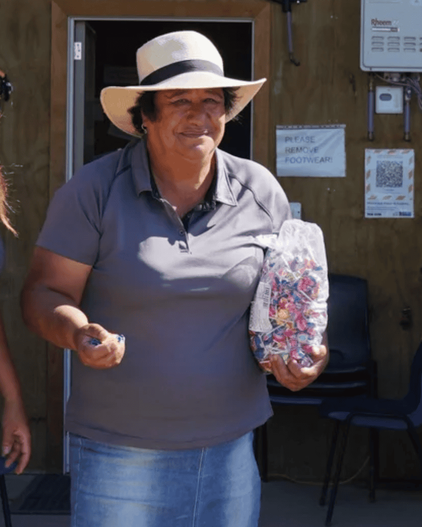Woman holding a bag of colorful beads outside Reigning Downs Hauora Centre.